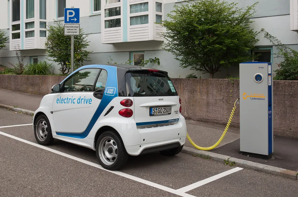 A small electric car plugged into a charging station